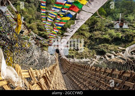 ancient holy bamboo bridge with many buddhist holy flags from unique perspective image is taken at chaksam bridge tawang arunachal pradesh india. Stock Photo