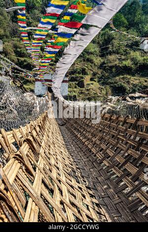 ancient holy bamboo bridge with many buddhist holy flags from unique perspective image is taken at chaksam bridge tawang arunachal pradesh india. Stock Photo