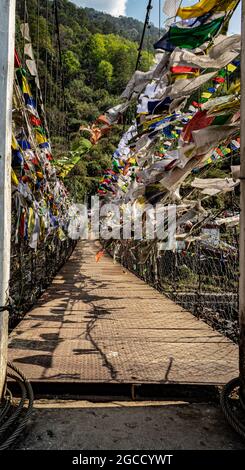 suspension iron bridge with many buddhist holy flags from unique perspective image is taken at chaksam bridge tawang arunachal pradesh india. Stock Photo