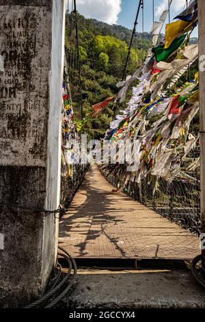 suspension iron bridge with many buddhist holy flags from unique perspective image is taken at chaksam bridge tawang arunachal pradesh india. Stock Photo