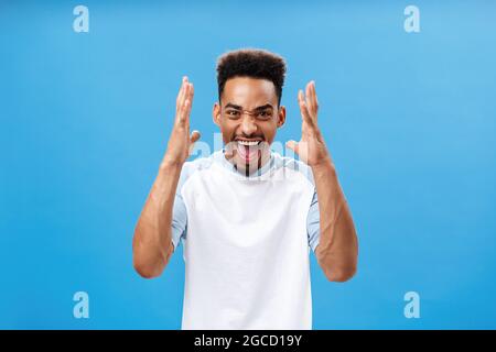 Waist-up shot of man going furious being in rage shouting and yelling from anger stressing out and arguing with girlfriend having fight shaking raised Stock Photo