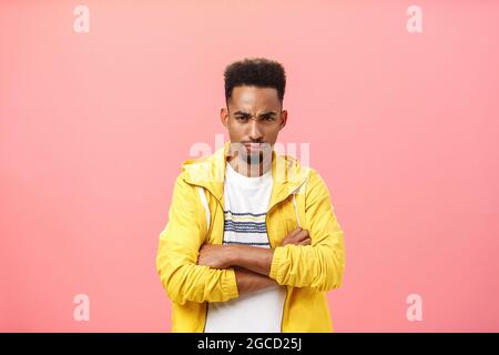 Displeased offended attractive african american male with beard and curly hairstyle frowning holding hands crossed pouting ready to cry, whining being Stock Photo