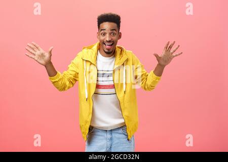 Hey jazz hands always in trend. Portrait of enthusiastic charismatic attractive dark-skinned man with beard and afro hairstyle raising palms and Stock Photo