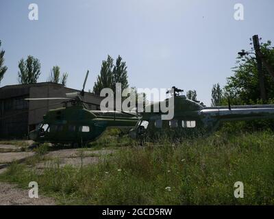 Old military abandoned helicopter. Broken non-working helicopter green. Stock Photo