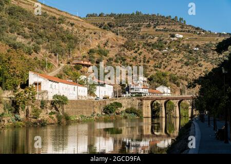 PINHAO, DOURO REGION, PORTUGAL - OCTOBER 22, 2017:  View on Quinta do Sagrado and  old stone bridge over Duoro river in Pinhao village, Portugal Stock Photo