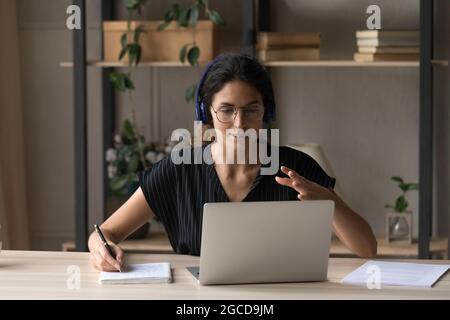 Close up woman in headphones leading online lesson, using laptop Stock Photo