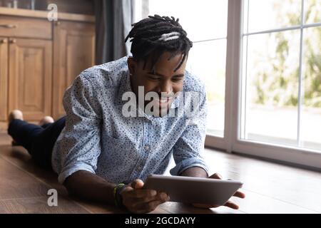 Smiling biracial man use tablet talking on webcam call Stock Photo