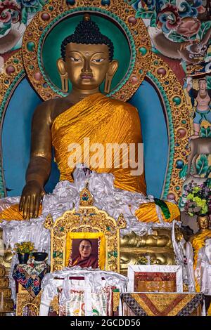 huge buddha golden statue decorated with religious flags and offerings at evening image is taken at tawang monastery arunachal pradesh india. Stock Photo