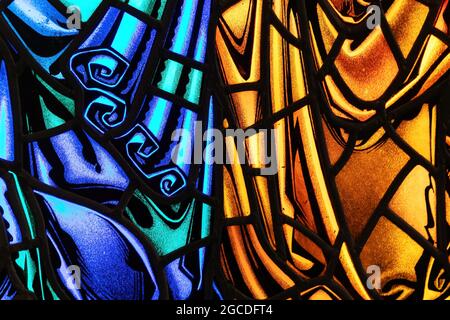 Close up and generic details of stained glass in vibrant blue and orange tones. Stock Photo