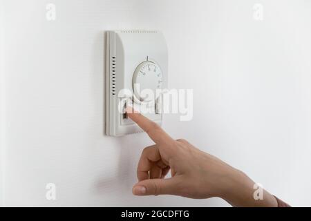Close up of woman adjust temperature on air conditioner Stock Photo