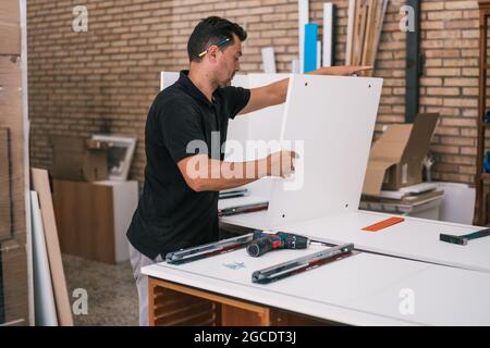 Man working on a kitchen furniture in a workshop Stock Photo