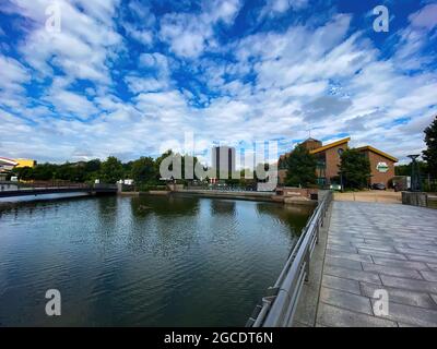 Oberhausen (Centro), Germany - July 9. 2021: View over water canal beyond beach on gasometer tower against summer sky Stock Photo