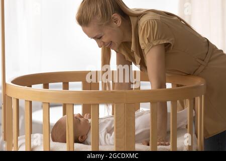 Smiling mother put to sleep newborn baby Stock Photo