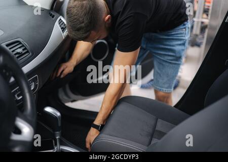 Man moves front seat in car for cleaning on self car washing. View from car Stock Photo