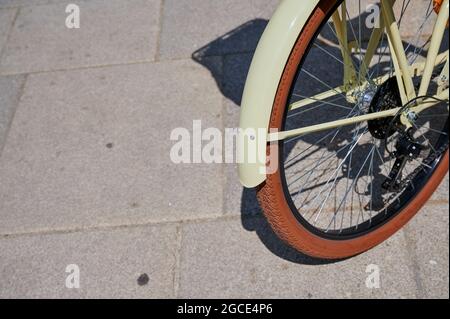 bicycle front wheel in yellow on grey asphalt Stock Photo