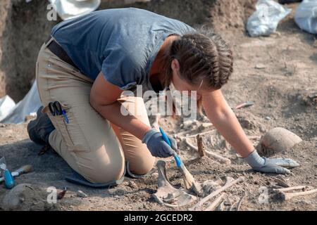 Vinča, Serbia, Sep 27, 2019: Female archaeologist working on human remains excavation Stock Photo