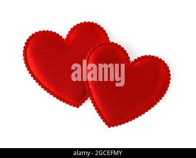Two red valentine hearts isolated on white background. Pair of vintage silk valentine hearts. Design element for love and togetherness concepts. Stock Photo