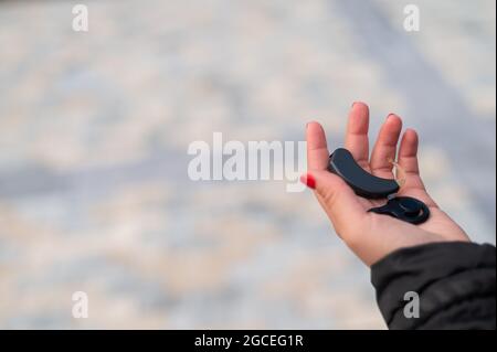 Close-up of a hearing aid in a female hand. Stock Photo