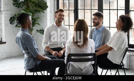 Smiling diverse people engaged in group counseling together Stock Photo
