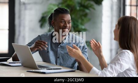 Smiling diverse colleagues have fun working in office Stock Photo