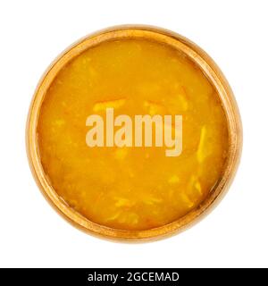 Orange jam, in a wooden bowl. Orange marmalade, a sweet and slightly bitter bread spread, made of cooked oranges, sugar and pectin. Stock Photo