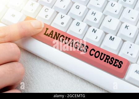 Hand writing sign Languages Courses. Word for set of classes or a plan of study on a foreign language Retyping Download History Files, Typing Online Stock Photo