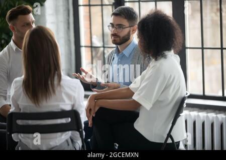 Diverse people sit in circle at mental session Stock Photo
