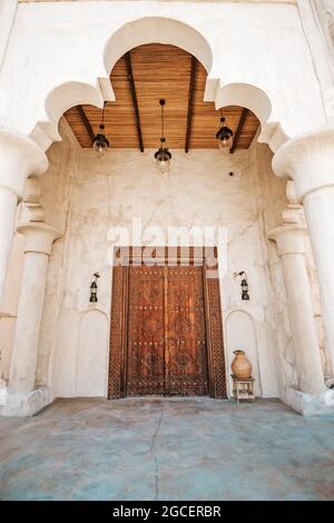 Antique wooden door with architectural arch in an ancient sandstone house in Bur Dubai near Creek area Stock Photo