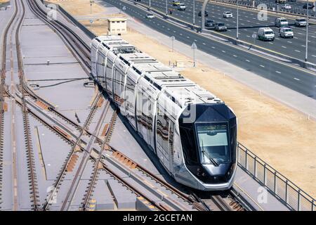 Hightech modern automated tram rides on the Sheikh Zayed Highway in Dubai, aerial view. Concept of public transport and railway interchanges Stock Photo