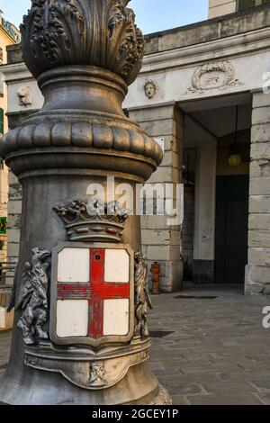 Close-up of a streetlight decorated with the coat of arms of Genoa city in front of the Carlo Felice Theatre, Liguria, Italy Stock Photo
