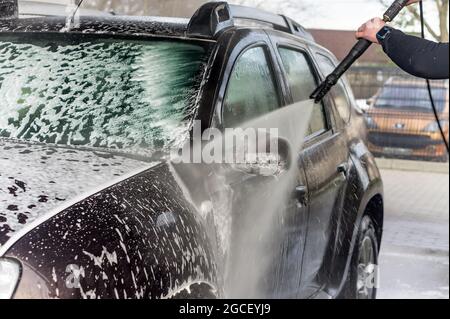 Kaliningrad, Russia, March 1, 2020. A man washes his car at a touchless car wash. Washing his brown Renault car. The SUV at the car wash. Stock Photo