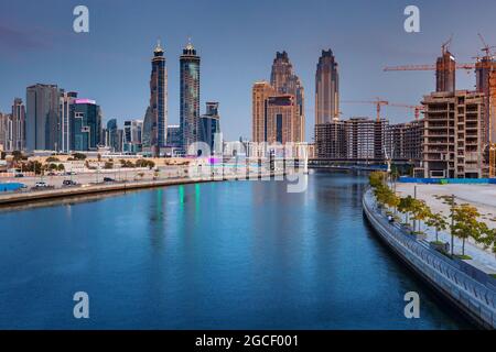 23 February 2021, Dubai, UAE: Dubai water canal and construction of skyscrapers at twilight Stock Photo