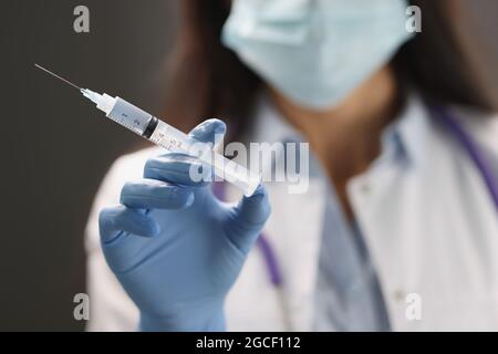 Doctor hand in blue gloves holds vaccine closeup Stock Photo