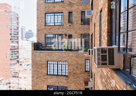 Window mounted air conditioners are used in New York City buildings that do not have central air, United States Stock Photo