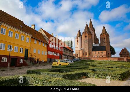 Beautiful street view of the town. Colourful traditonal houses along the road with the Church of Our Lady in the background. Kalundborg, Denmark. Stock Photo