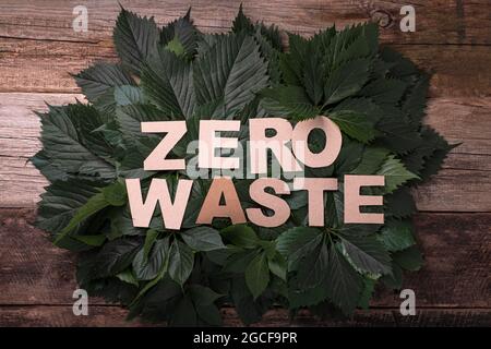 Zero waste paper text with green leaves on a wooden background. top view Stock Photo