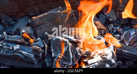 Bonfire embers. BBQ coals with fire. Close-up of the combustion process of wood, charcoal for barbecue Stock Photo