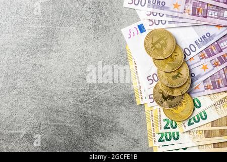Euro banknotes and bitcoins. Coins of a cryptocurrency. Top view. Stock Photo