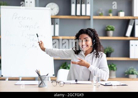Video conference with teacher at home, call with personal tutor, audio course, distance and e-learning education, lesson. Happy millennial black lady Stock Photo