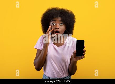 Emotional black woman demonstrating smartphone with empty screen Stock ...