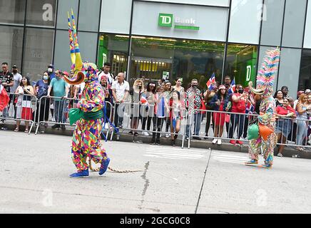 People dressed as Diablos Cojuelos attend the Dominican Day Parade on August 8, 2021 on the Avenue of the Americas in New York, New York. Robin Platzer/ Twin Images/ Credit: Sipa USA/Alamy Live News Stock Photo