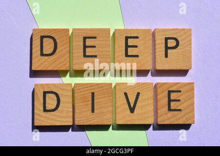 Deep Dive, words in wooden alphabet  letters isolated on background as banner headline Stock Photo