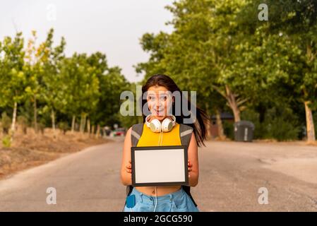 Young caucasian girl showing blank board in the park Stock Photo