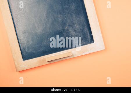 A top view of a small wall chalkboard for schedules on orange background with a copy space Stock Photo