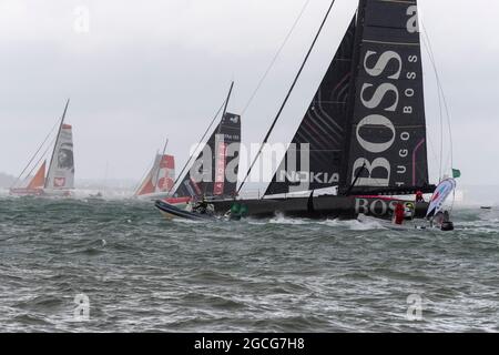 Cowes Isle of Wight, UK. 8th August 2021. Rolex Fastnet; Hugo Boss , IMOCA 60 heading out of the Solent in 35 knots of  wind at the start of the Fastnet Race. Credit Gary Blake /Alamy Live News Stock Photo