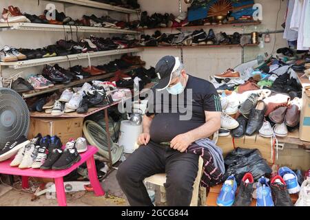 Beirut, Lebanon. 08th Aug, 2021. An old shoes vendor takes a rest at Souq el Ahad (Sunday Market), Beirut, Lebanon, on August 8, 2021. Prices hike have become a hard issue for Lebanon, as more than half of the population has fallen under the poverty line since the economic and financial crisis started in 2019. Middle class has been wiped away and less and less people can afford to purchase things as shoes and garments in the shops.(Photo by Elisa Gestri/Sipa USA) Credit: Sipa USA/Alamy Live News Stock Photo