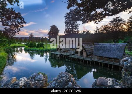Old straw houses surrounded by a pond in the Bally Park in Schoenenwerd, Switzerland Stock Photo