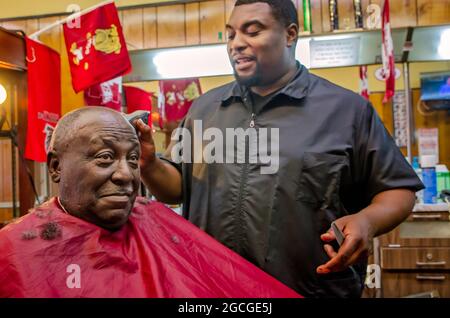 A barber talks to his customer as he cuts hair at Gibson's Hair Styles and Cuts, April 23, 2013, in West Point, Mississippi. Locals say jobs are neede Stock Photo