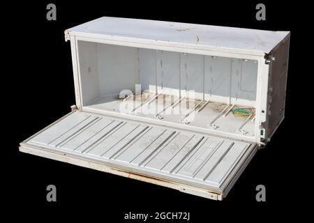 Broken old refrigerator in a garbage dump isolated on  black Stock Photo
