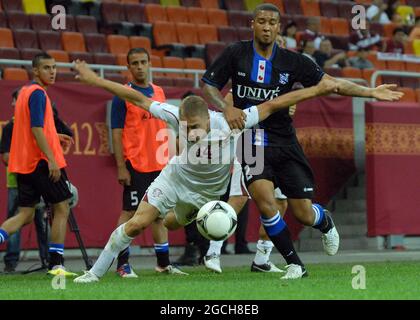 BUCHAREST, ROMANIA - AUGUST 9, 2012: Mihai Roman (L) of Rapid and Gianni Zuiverloon (R) of Heerenveen pictured in action during the second leg of the 2012/13 UEFA Europa League Third Qualifying Round game between Rapid Bucuresti and FC Heerenveen at National Arena. Stock Photo